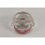 A Whitefriars millefiori glass paperweight, the facet cut, with concentrtic canes in red, white,