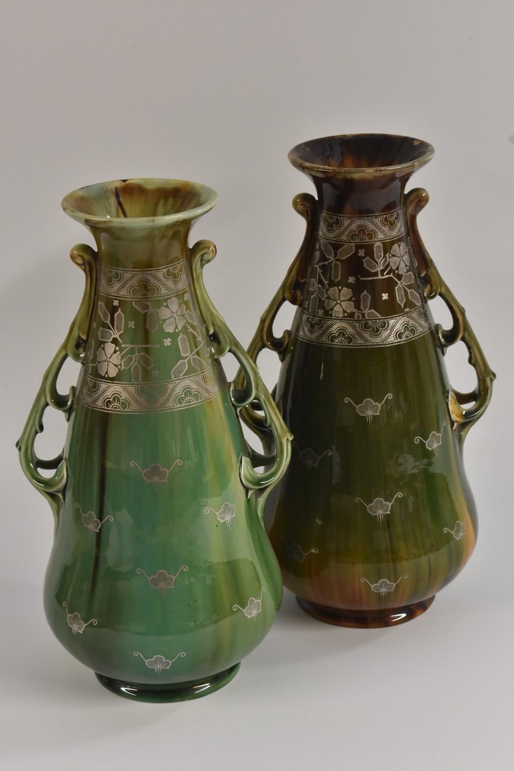 A pair of Mintons Art Nouveau two handled spreading ovoid vases,