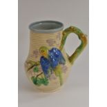 A Clarice Cliff jug, in relief with budgerigar, in blue and green, on a mushroom, rustic handle, 22.