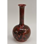 A Bernard Moore bottle vase, red lustre flambé glazed, decorated with scrolling foliage, 26cm,