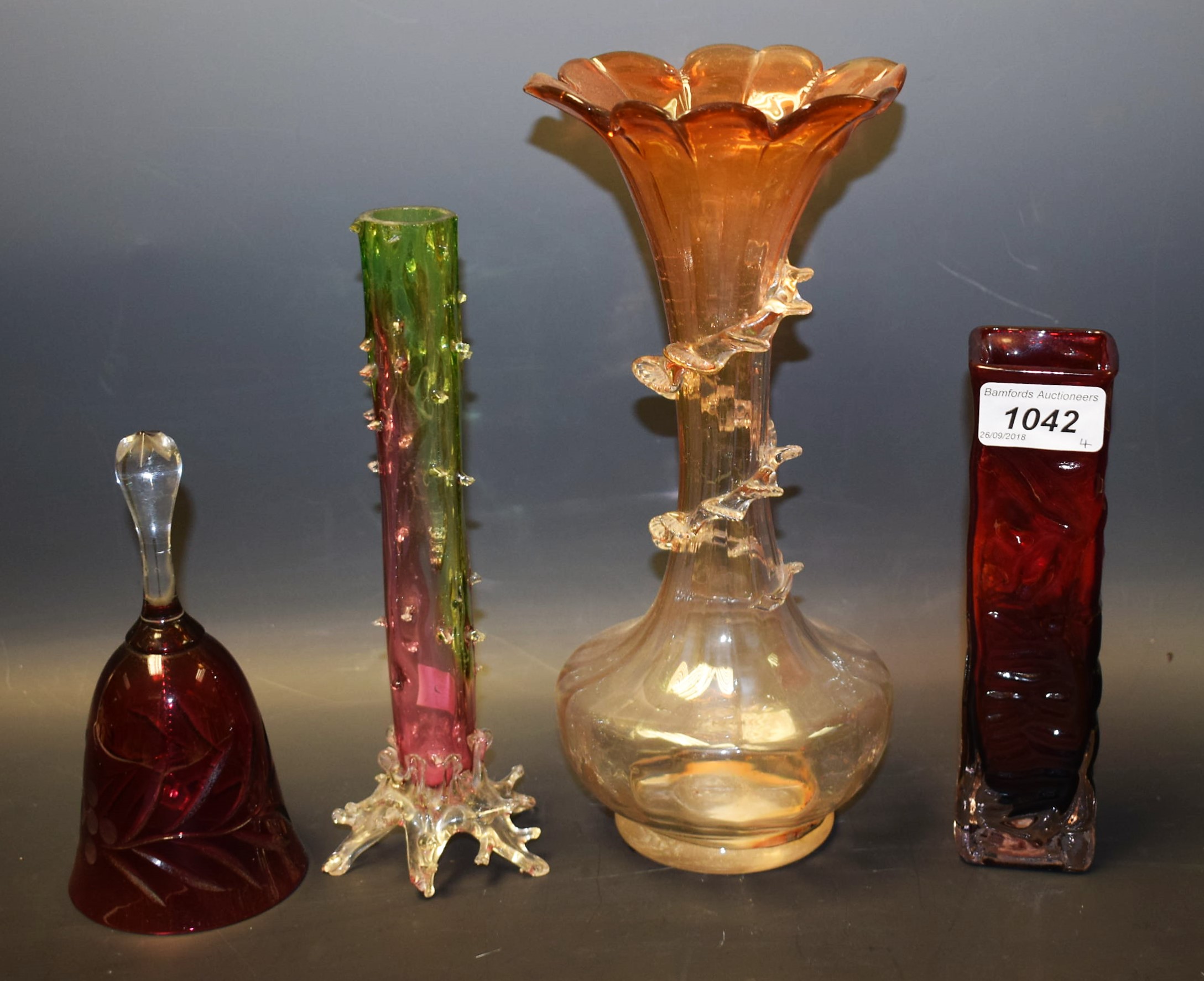 A late 19th century glass vase, a similar bud vase, a 1970's red glass vase,
