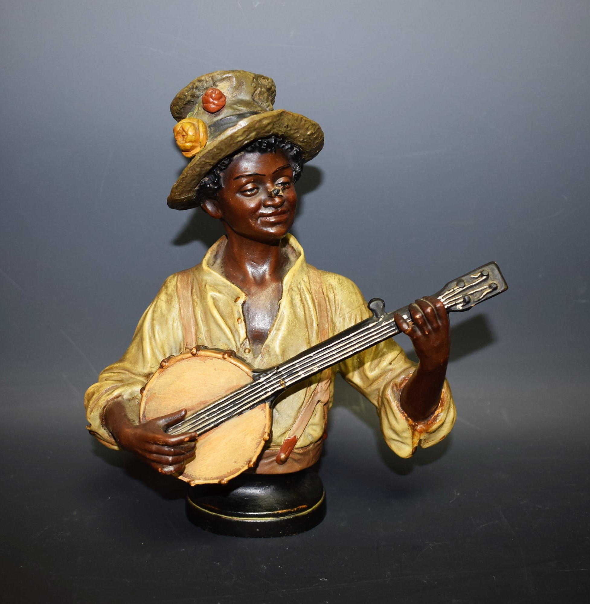 A Continental pottery model Blackamoor Banjo Player,