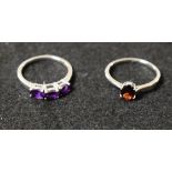 A sterling silver ring set with purple semi precious stones; another,