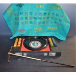 A roulette wheel, 25cm diam, cased, chips and baize playing surface ensuite,