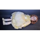 A bisque head doll, in the style of Kammer & Reinhardt, with sleeping eyes, closed mouth,