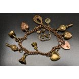 A Victorian 9ct rose gold charm bracelet, padlock clasp, suspending eleven assorted yellow,