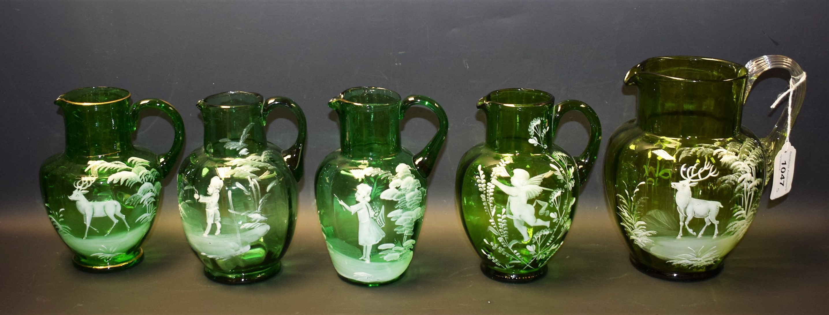 A Mary Gregory fluted green glass jug, enamelled in white with stags and foliage, 18cm high, c.