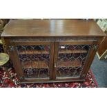 A Jaycee oak bookcase, lunette carved frieze, lead glazed doors enclosing adjustable shelving.