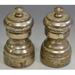 A pair of silver pepper mills,