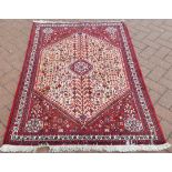 A hand woven Persian Abadeh rug, central medallion set amid stylized flora,