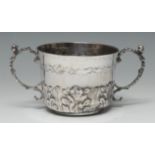 A Charles II silver porringer, chased with bands of acanthus, scroll handles capped with masks,
