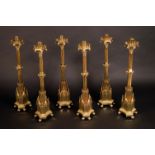 A remarkable set of six substantial early Victorian Gothic Revival gilt brass candlesticks,