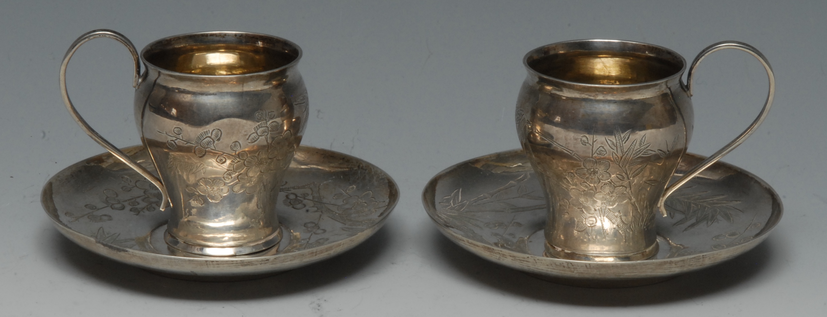A pair of Chinese silver ogee coffee cups and saucers,