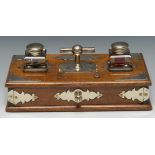 A Victorian rectangular oak and silver plated desk stand, with central bar handle, two wells,