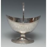 A George III silver boat shaped pedestal sugar basket, swing handle, reeded borders,