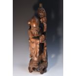 A large Chinese hardwood carving, of Shou Lao, he stands, holding a ripe peach, a crane at his side,