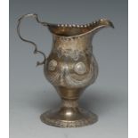 A George III silver pedestal cream jug, chased in the Adam taste with ribbon-tied swags,