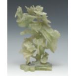 A Chinese green jade group, carved with a phoenix perched in foliage,