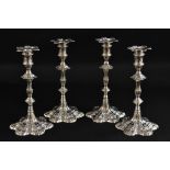 A composed set of four early George III Rococo cast table candlesticks, detachable nozzles,