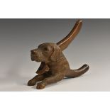A 19th century Black Forest novelty cracker, as a recumbent dog, paws outstretched,