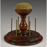 A Victorian blackwood seamstress's bobbin stand, baluster central column crested by a pin cushion,