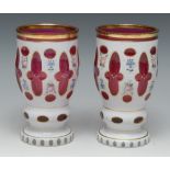 A pair of late 19th century Bohemian ruby glass vases, overlaid in white and painted flowers,