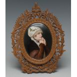 A German oval plaque, painted with a portrait of a lady wearing a bonnet,