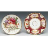 A Rockingham shaped circular plate, painted with flowers in gilt cartouches,