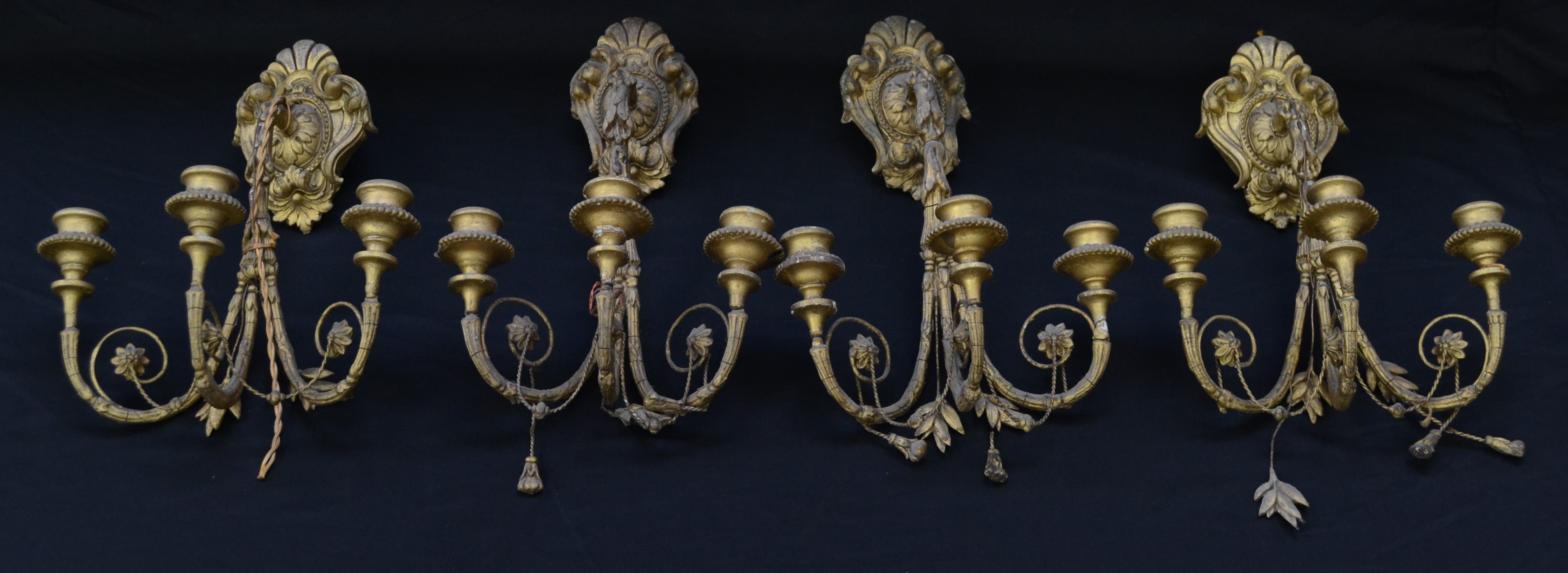 A set of four 19th century giltwood and gesso three-light wall sconces, campana sconces,