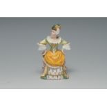 A Minton candle snuffer, Mrs. Malaprop, painted in polychrome, with yellow apron, 9cm high, c.