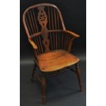 An early 19th century yew and elm Windsor elbow chair, hooped back, shaped and pierced wheel splat,