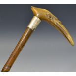 A 19th century walking stick the horn handle carved with a bird's head, glass eyes, silver collar,