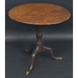 An 18th century mahogany occasional table, the one piece circular top tilting on a turned column,