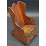 A mid 18th century child's oak wing back rocking chair, pierced hand holes, shaped apron, 61cm high,