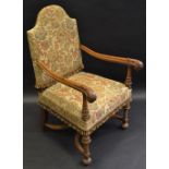 A walnut open arm chair, padded back and seat, outswept arms, acanthus leaf terminals,