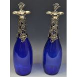 A pair of contemporary 'Bristol Blue' bottle decanters, the necks cast with leafy vine,