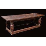 An Elizabethan design oak refectory trestle dining table, three plank top, turned baluster supports,