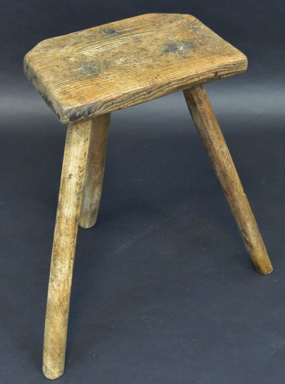 A 19th century canted rectangular milking parlour stool, three legs,