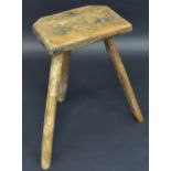 A 19th century canted rectangular milking parlour stool, three legs,