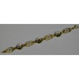 A gold and crystal bracelet, set with three circular bosses with gun dogs and pheasant,