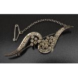 A swirling S ribbon diamond encrusted brooch,