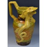 A large Art Pottery beer jug, the spout as a mystical creature, banded in tones of green,