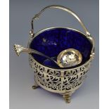 A silver ogee basket, pierced, swing handle, blue glass liner, 14cm high,