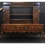 An 18th century oak dresser, the asssociated plate rack with shaped cornice, open shelves,