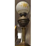 A brass column oil lamp, the reservoir on a gimble, opaque glass shade, Prince and Symmons,