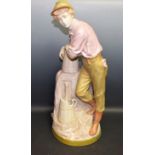 A large Royal Dux figure, of a boy by a water pump, he stands leaning on a coopered jug,