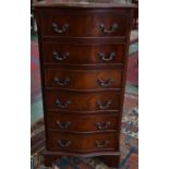 A tall mahogany serpentine fronted chest of six drawers