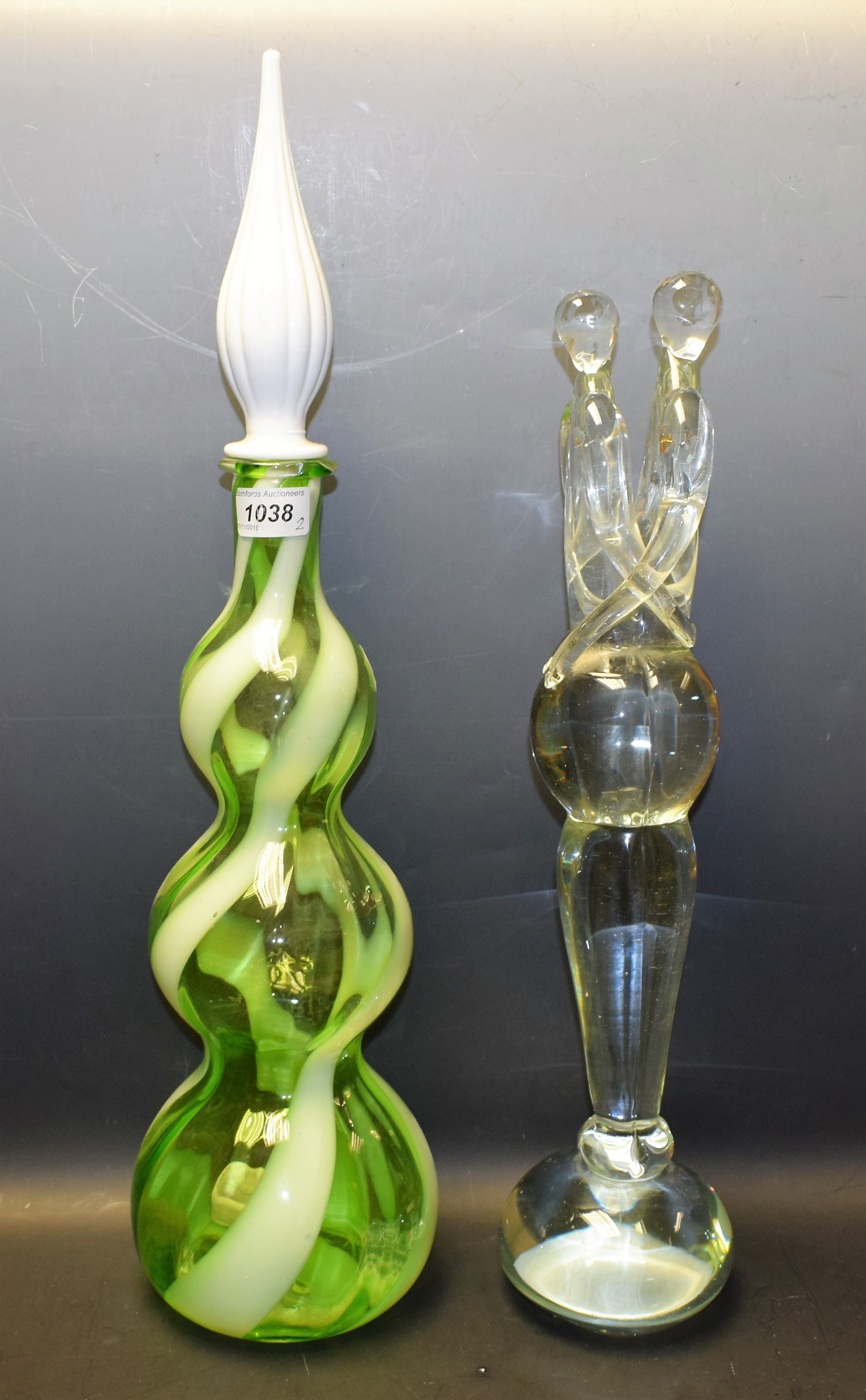 A Murano clear glass sculpture, two entwined figures; a 1960's spiral glass bottle vase,