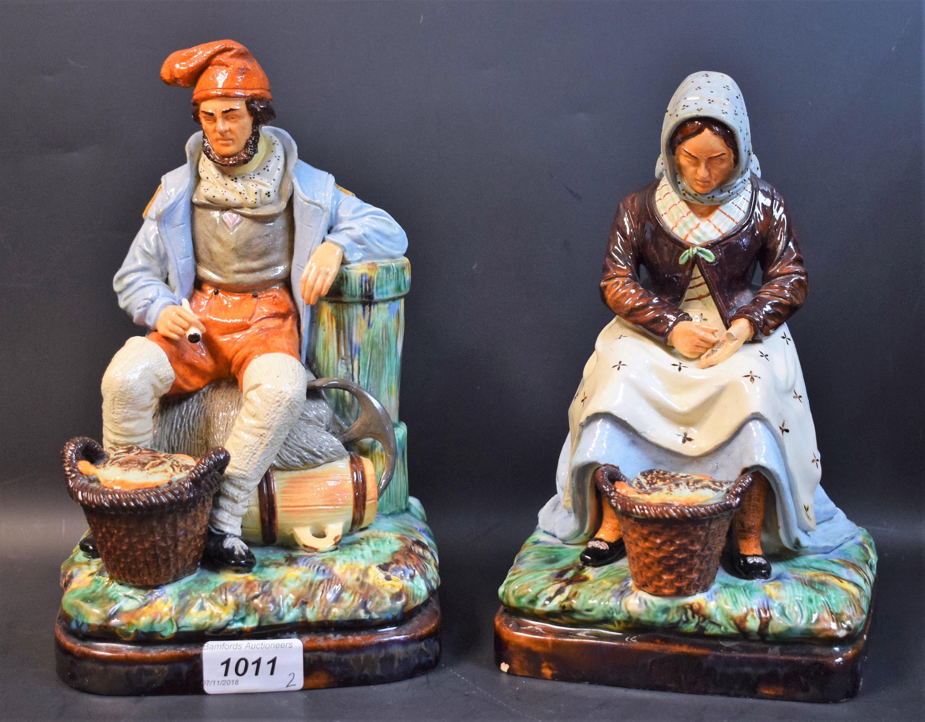 A pair of 19th century Majolica figures, of a fisherman and fisherwoman,