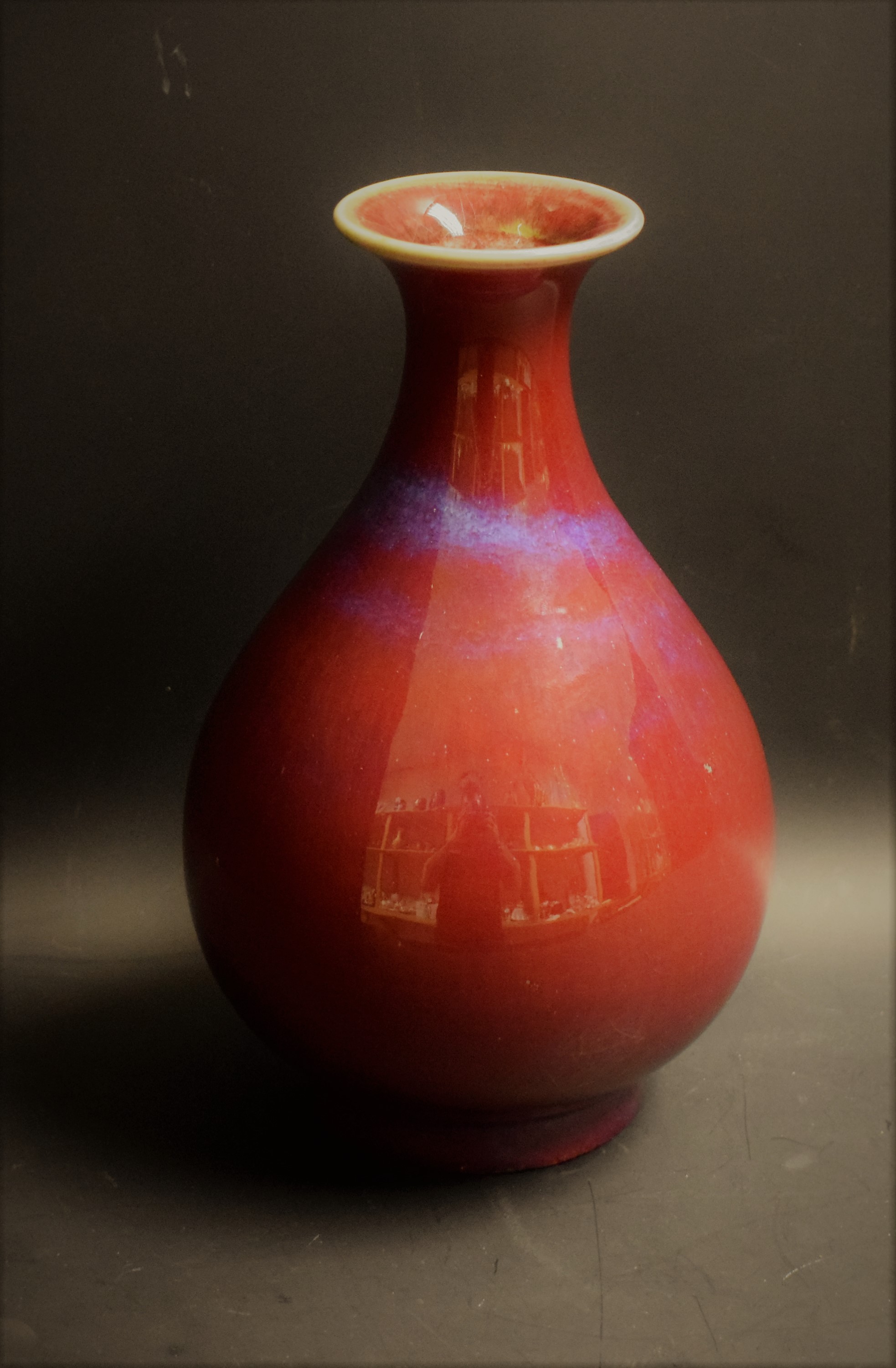 A Chinese monochrome ovoid vase, flared rim, glazed in mottled tones of red and purple blushes,